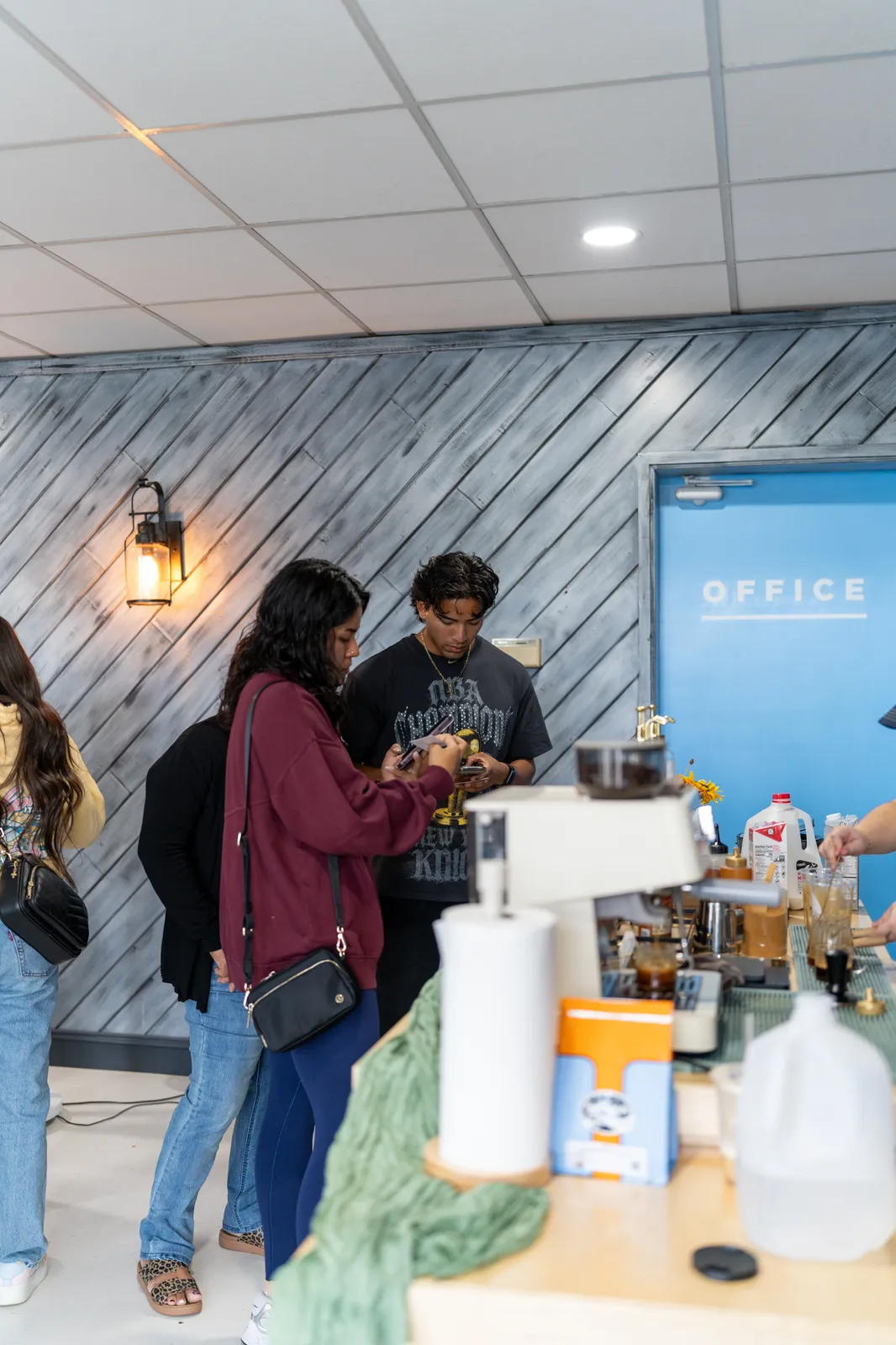 Guests gather at the cart to order beside the blue office door.