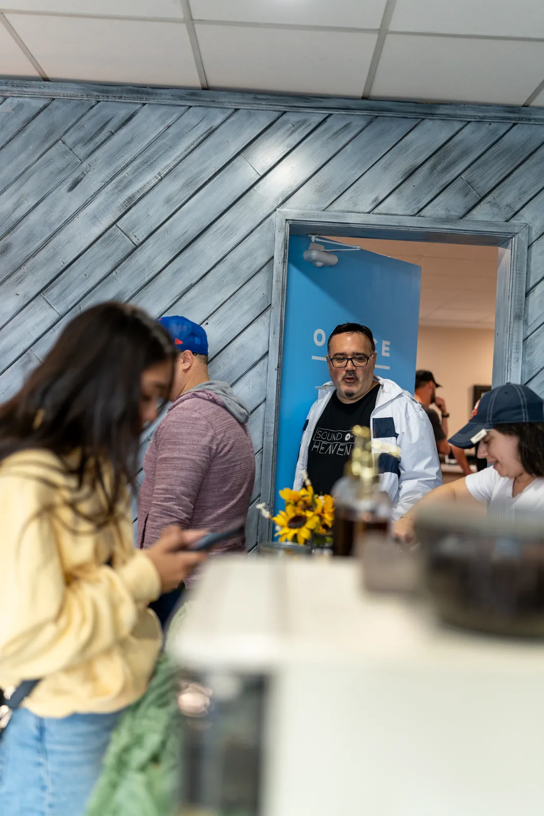 Guests chat at the counter as a sunflower vase brightens the cart.