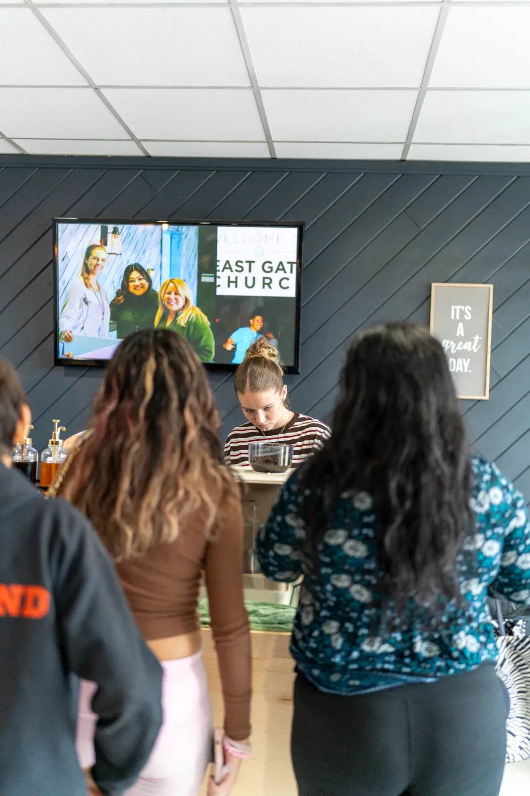 Guests line up at the cart beneath the lobby welcome screen.